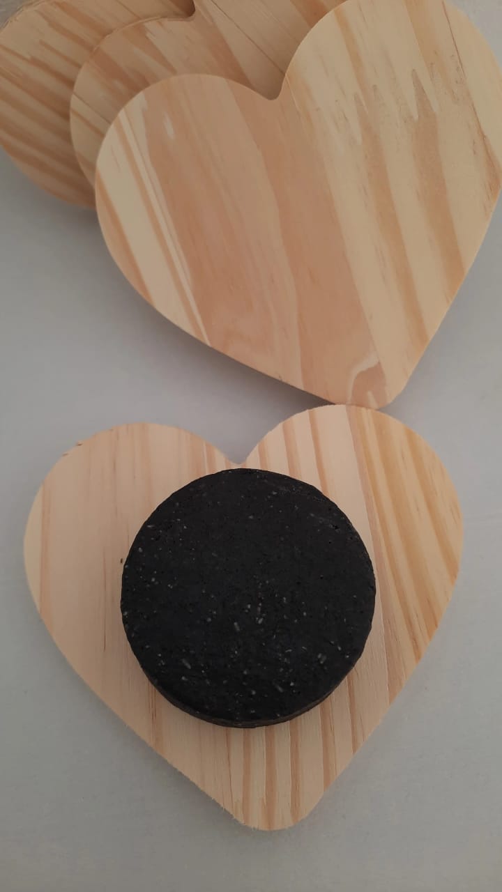 Wooden heart-shaped coasters with a black rubber pad on a light gray background