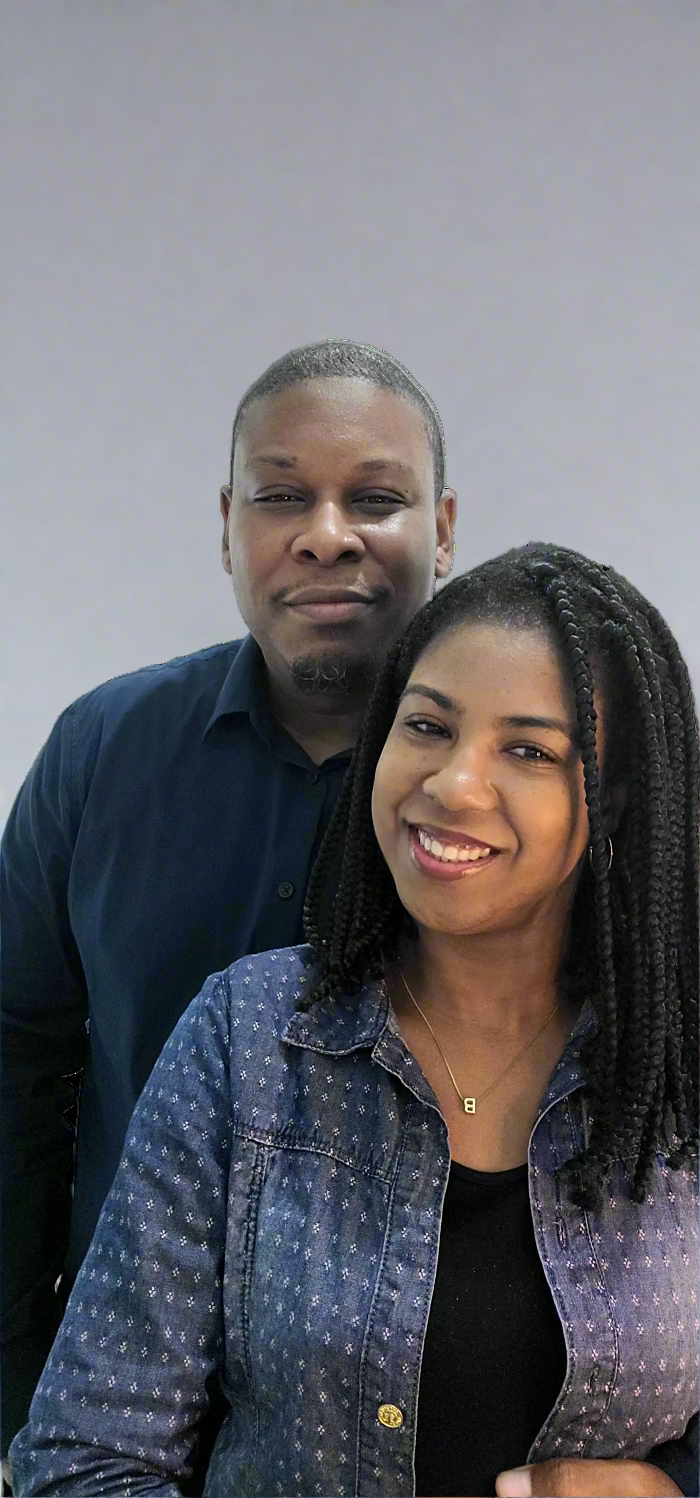 Two people standing close together against a plain background